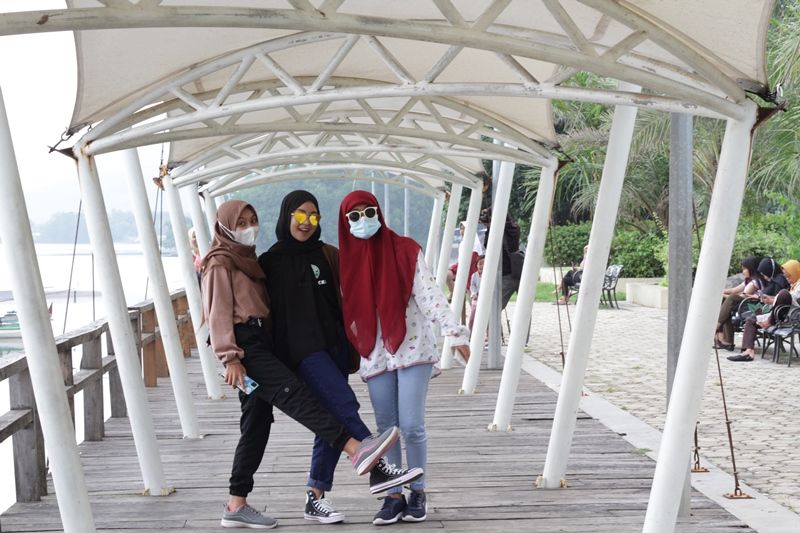 TENDA BERTEDUH. Pengunjung berfoto di bawah tenda peneduh di bibir Pantai Bletok, Kec. Bungatan, Situbondo. Foto: Hozaini