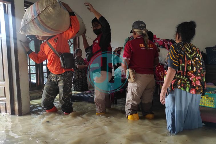 PANGGUL: Akibat dari meluapnya kali lamong yang melanda di tiga desa di Kabupaten Mojokerto. Salah seorang relawan mengevakuasi barang yang bisa diselamatkan, Kamis 10 Februari 2022. Fotografer: Karina Norhadini