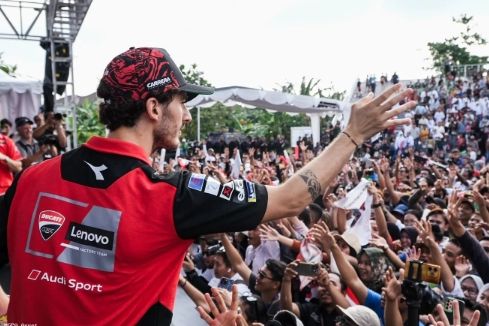 Francesco Bagnaia membagikan merchandise t-shirt kepada fans MotoGP yang hadir di Teras Udayana, Kota Mataram, Rabu, 1 Oktober 2025. Dok: Mandalika Grand Prix Association (MGPA)