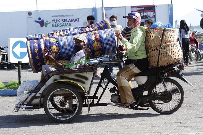 JASA ANGKUT. Seorang pedagang dari Kepulauan Madura menumpang becak motor untuk membawa barang dagangan di Pelabuhan Kalbut, Mangaran, Situbondo, Sabtu, 12 Juni 2021. Foto: Hozaini