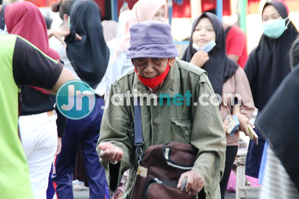 BERHARAP: Seorang lelaki lanjut usia mengenakan tongkat kayu menerobos keramaian pengunjung CFD sambil menadahkan tangan berharap ada pengunjung memberinya uang, Minggu, 25 Oktober 2020. Fotografer: Hozaini