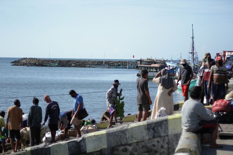 JALUR PERDAGANGAN. Pedagang dari Kepulauan Madura tiba di dermaga Pelabuhan Kalbut, Tanjungpecinan, Mangaran, Situbondo, membawa barang dagangan, Sabtu, 12 Juni 2021. Foto: Hozaini