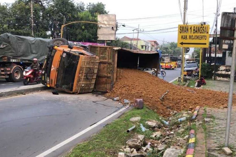 Tabrak Median Jalan, Truk Bermuatan Tanah Terguling di Jalan Raya Bangsal Mojokerto