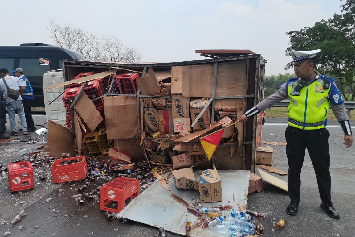 Pecah Ban, Truk Boks Bermuatan Teh Botol Terguling di Tol Sumo 