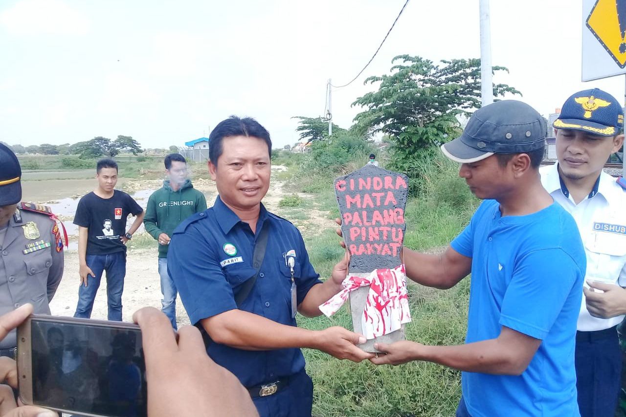 Protes Jalur Kereta Tanpa Palang Pintu, Warga Gresik Beri Batu Nisan