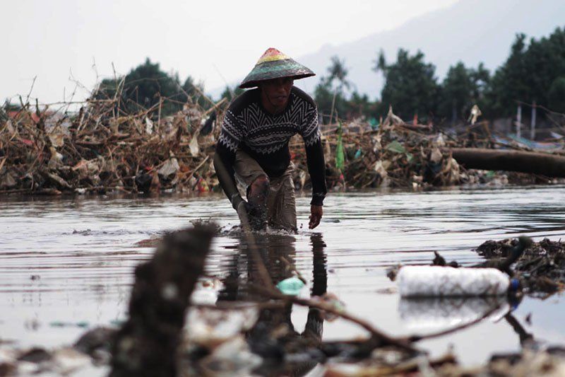 KOTORAN SUNGAI: Seorang nelayan Besuki, Kabupaten Situbondo saat membersihkan kotoran sampah di Pantai Bong Pesisir, Jumat 17 Desember 2021 Foto: Hozaini