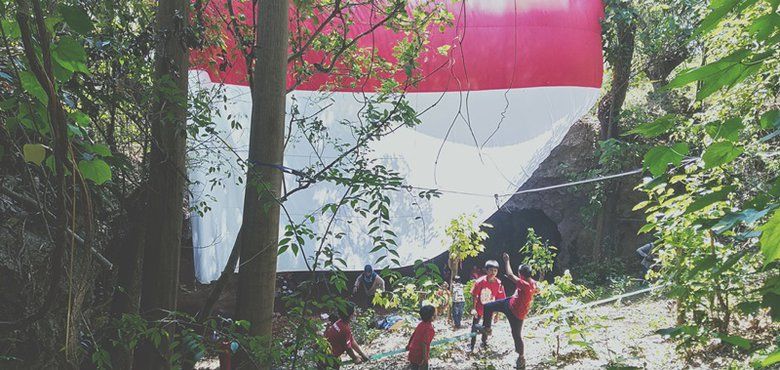 Keharuan Atlet Panjat Tebing Kibarkan Bendera Merah Putih Raksasa di Goa Gajah