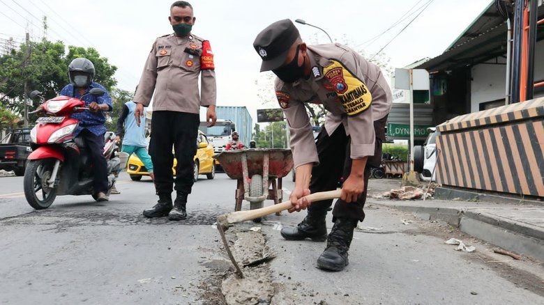 Cegah Kecelakaan, Anggota Polsek Ini Tambal Jalan Berlubang
