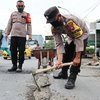 Cegah Kecelakaan, Anggota Polsek Ini Tambal Jalan Berlubang